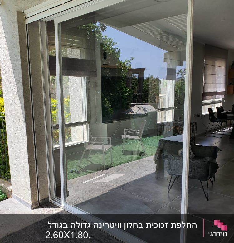דלת זכוכית גדולה עם מסגרת לבנה במרפסת